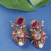 Ornate earrings with red gemstones, pearls, and gold accents
