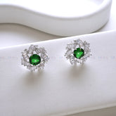 Pair of earrings with green gemstones on a white background