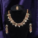 Jewelry set with necklace, earrings, and ring on a black stand against a purple fabric background