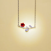 Necklace with a red flower and branch pendant on a beige background