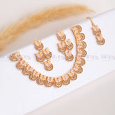 Rose gold jewelry set on a white surface with 'Kiran' branding.
