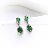 Pair of green teardrop earrings on a white background