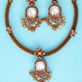 Ornate necklace with pearl-like stones on a light blue background