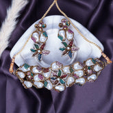 Ornate necklace and earrings on a white stone with a purple fabric background