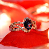 Gold ring with a dark gemstone on a red fabric background