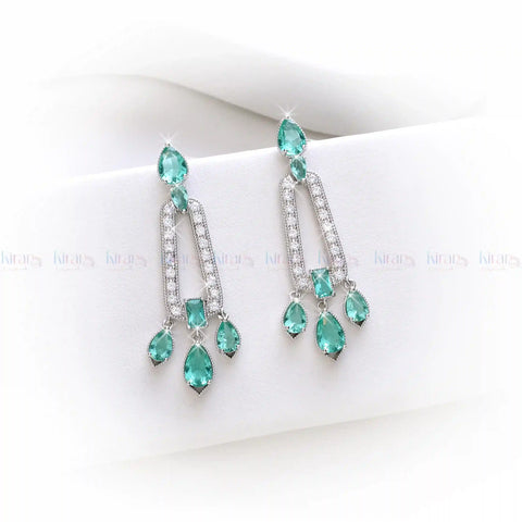 Teal chandelier earrings on a white surface with "KiranDan" branding.