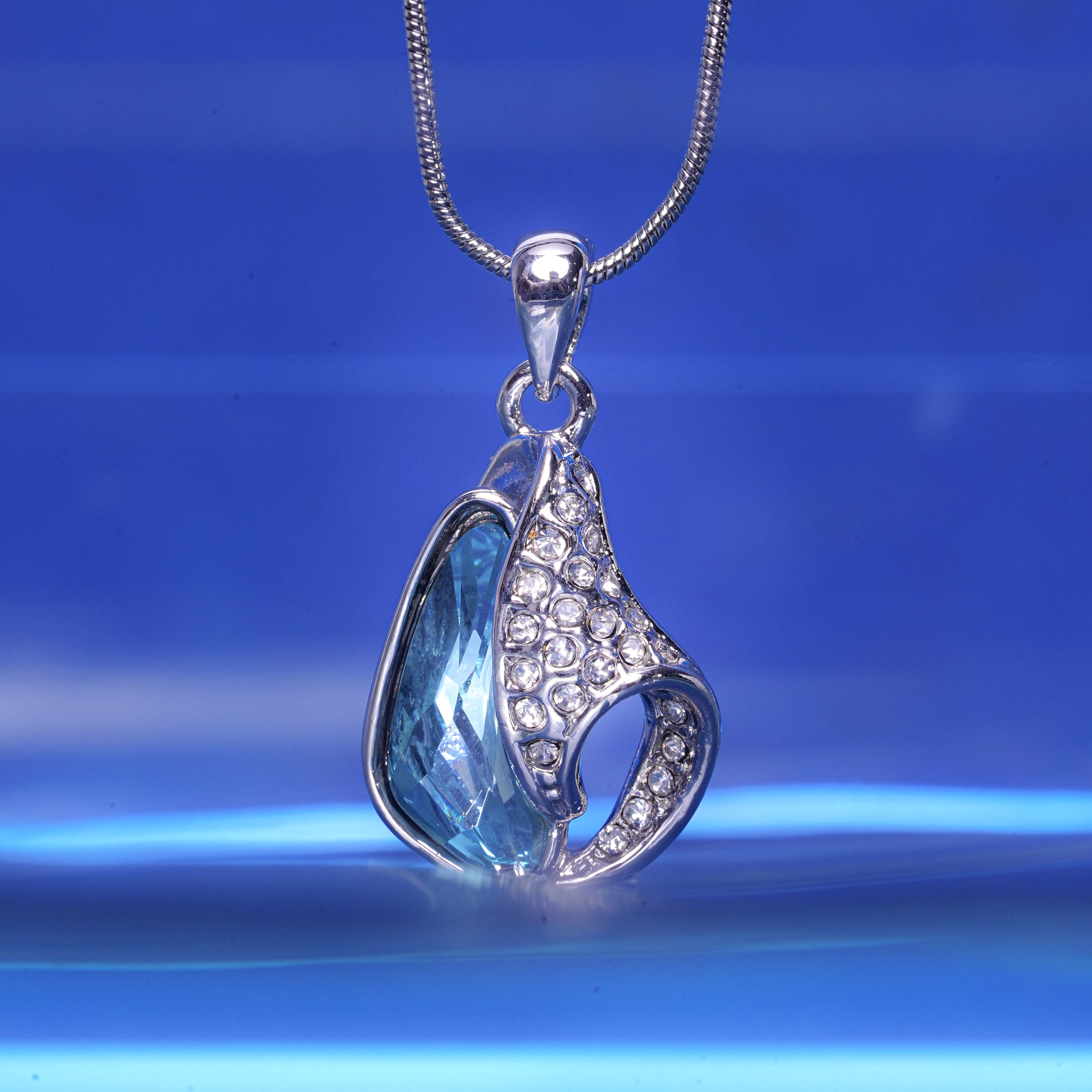 Silver pendant with blue stone on a blue background