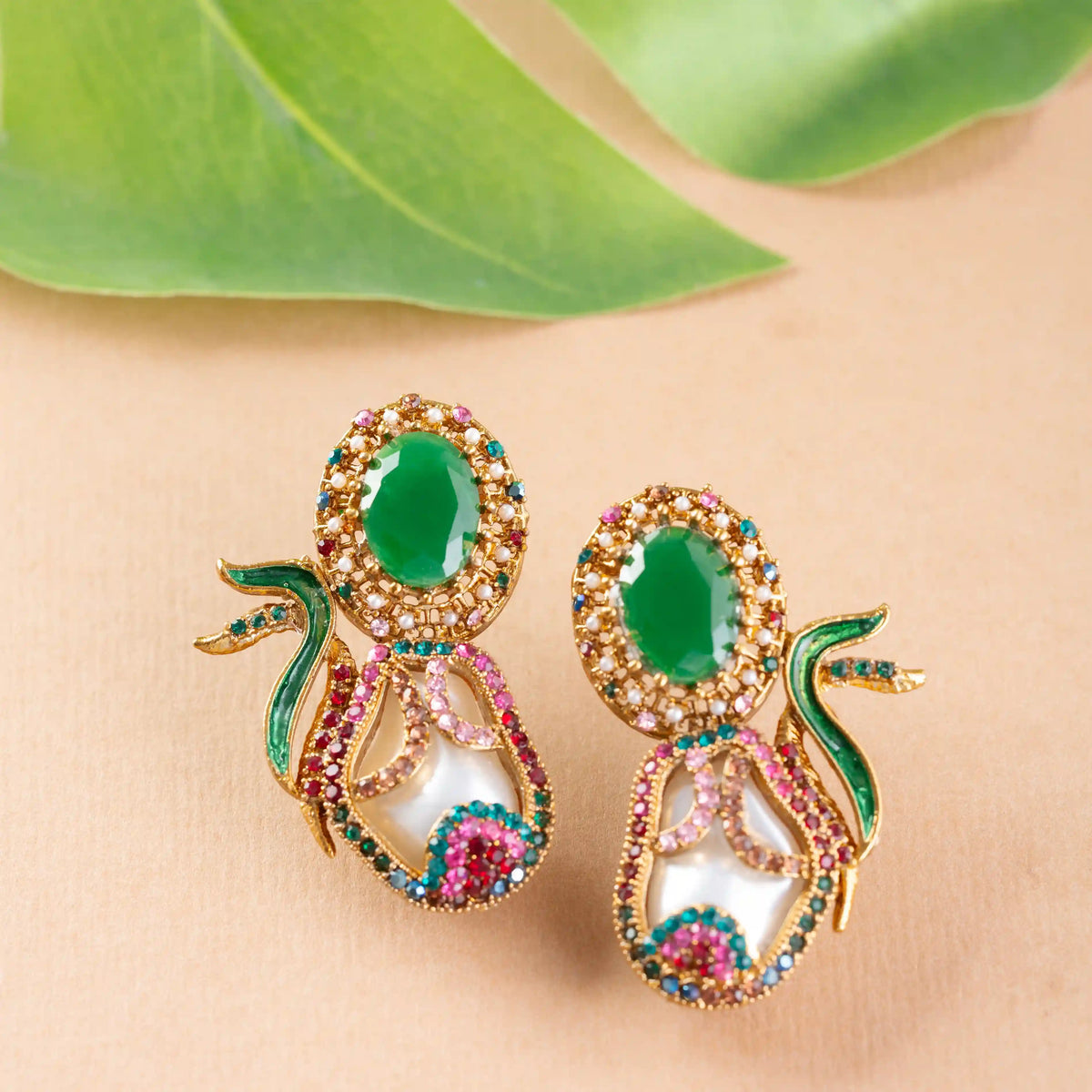 Ornate earrings with green gemstones and gold