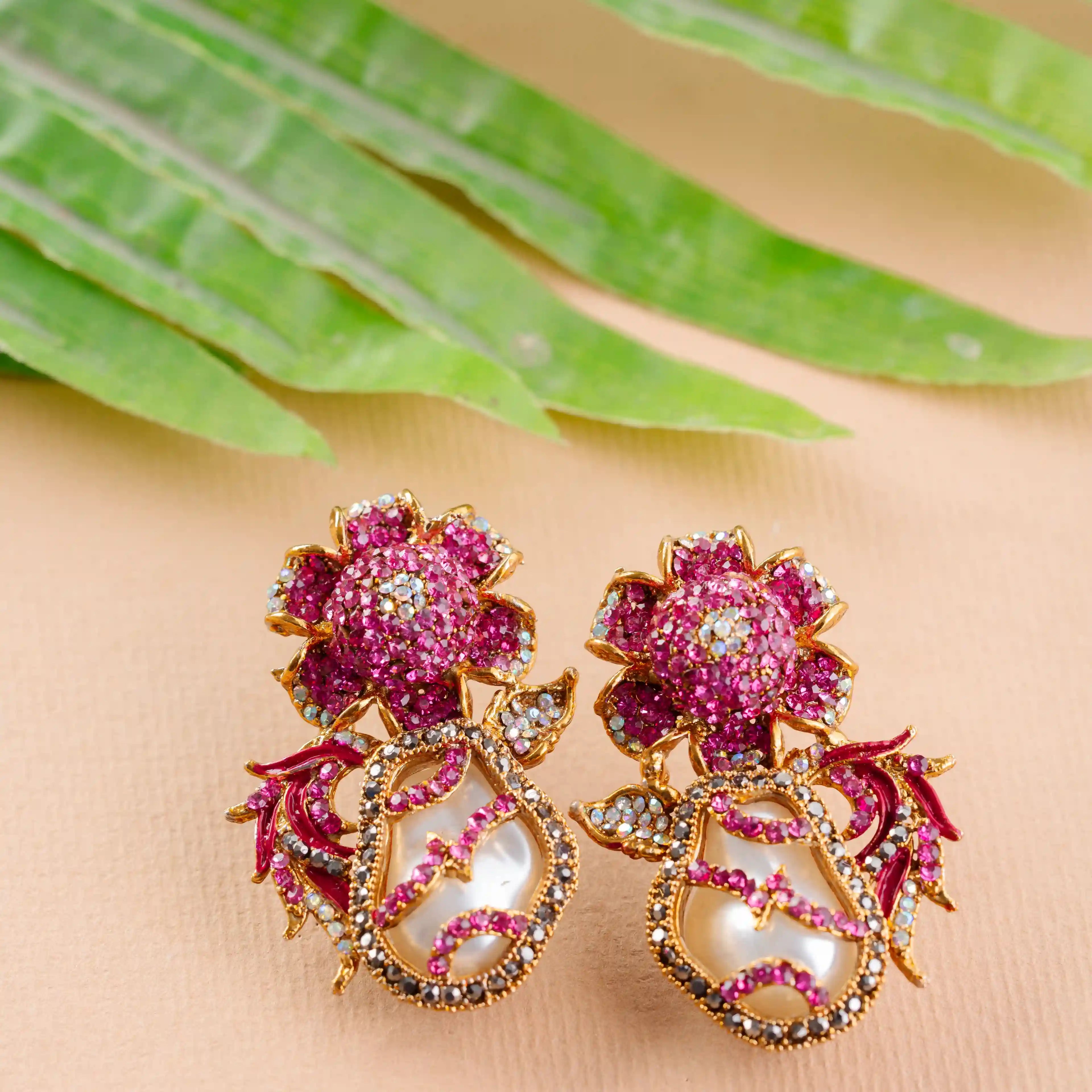 Decorative earrings with pink floral design on a beige