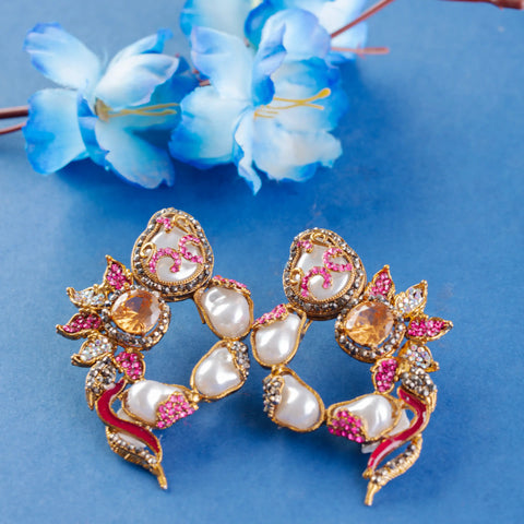 Decorative earrings with pearls and gemstones on a blue background