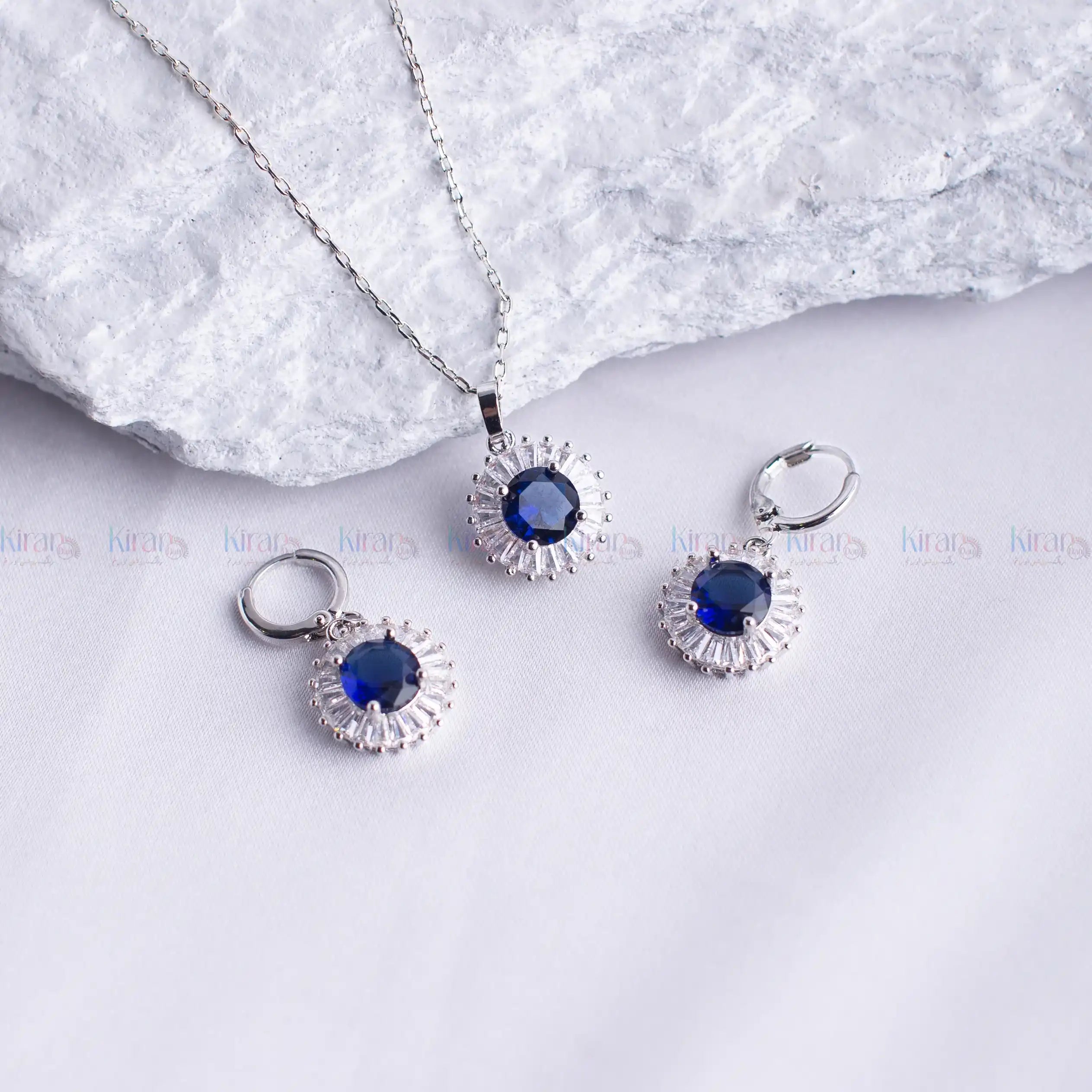 Silver jewelry set with blue stones on a white background