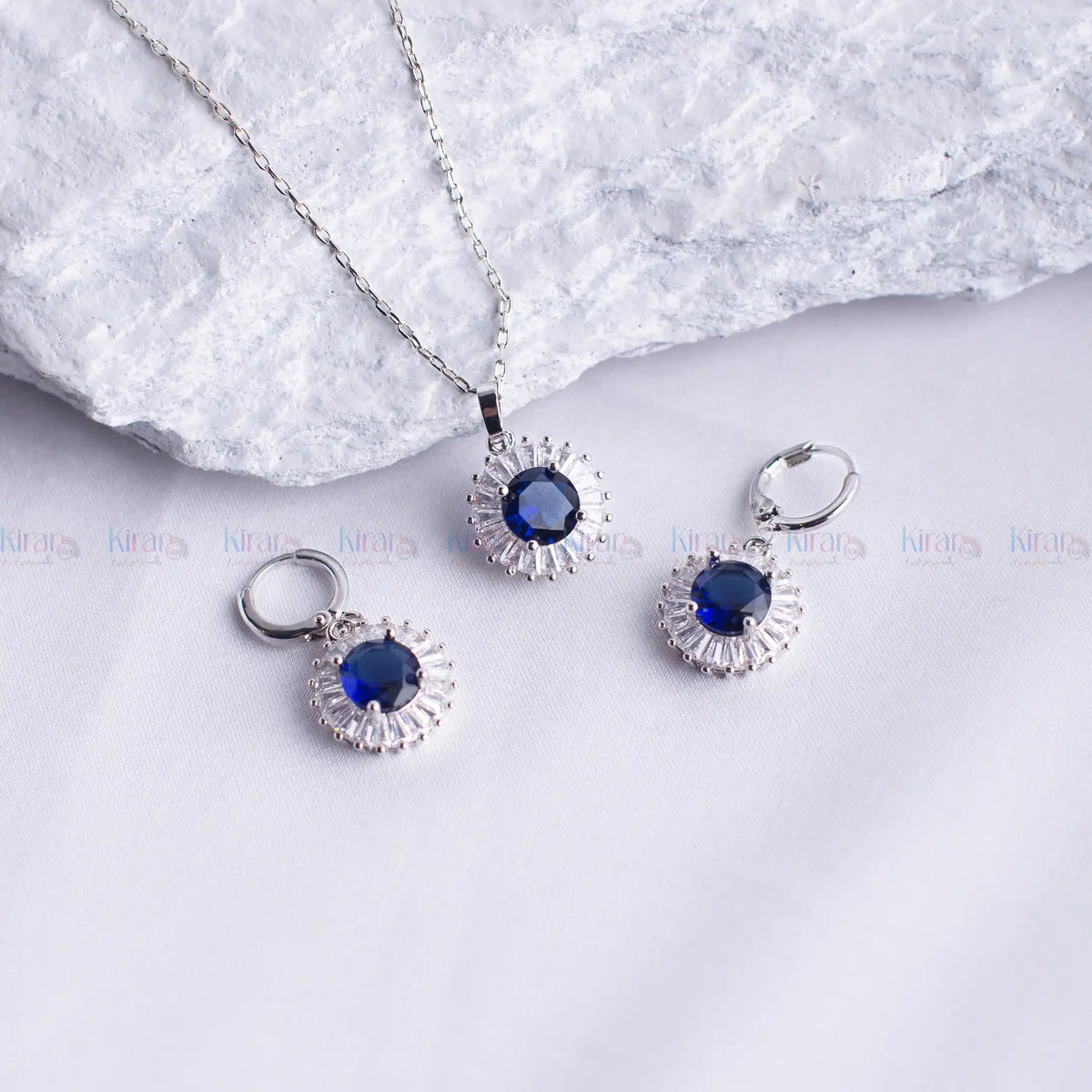 Silver jewelry set with blue stones on a white background