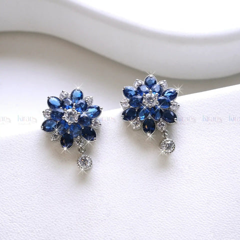 Pair of blue flower-shaped earrings on a white surface