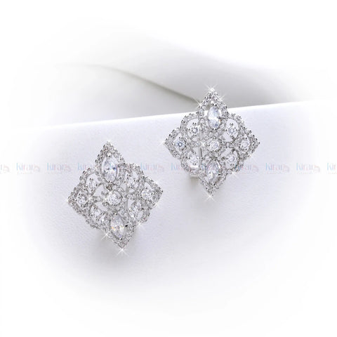 Pair of silver earrings with clear gemstones on a white surface