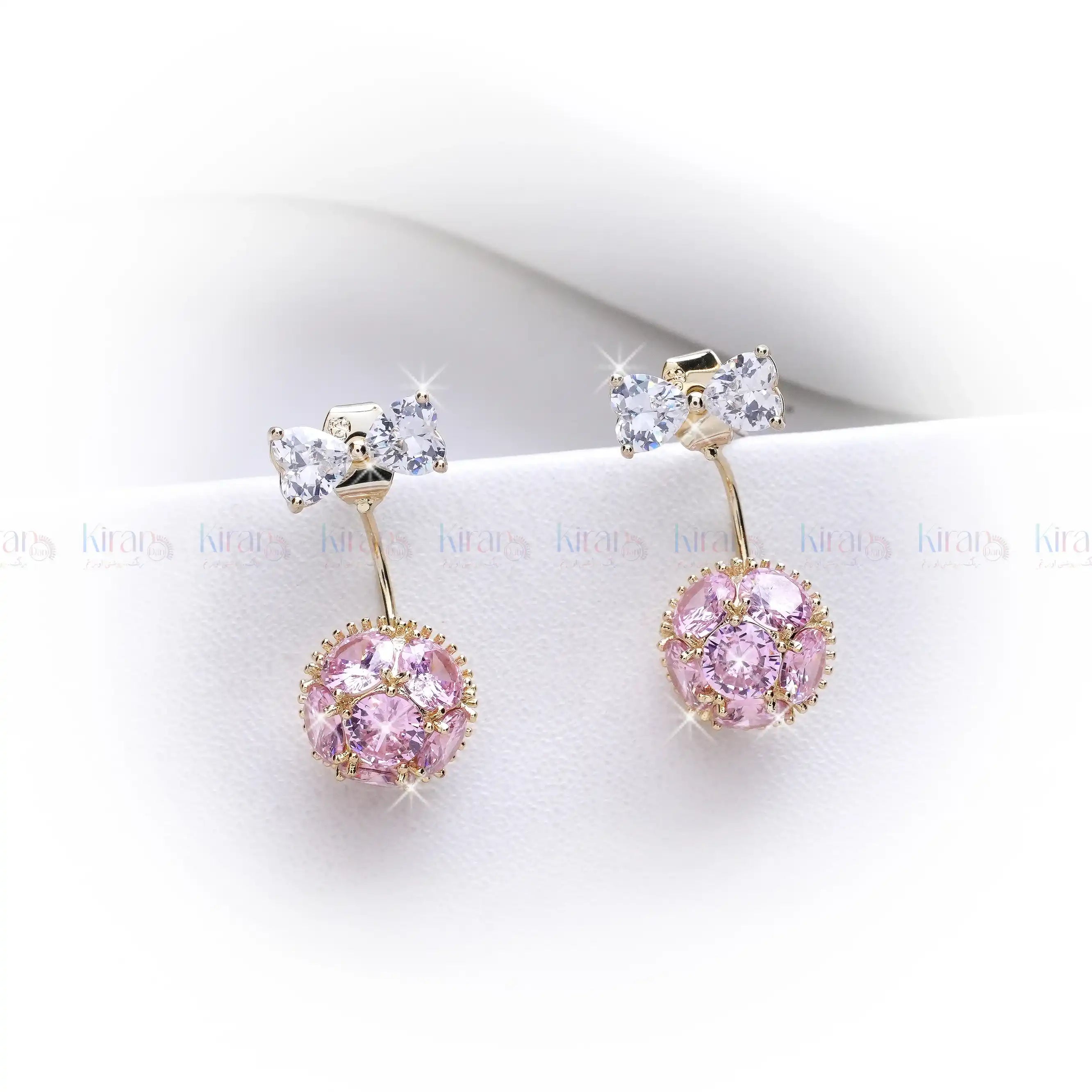 Pair of earrings with pink gemstones and gold accents on a white background