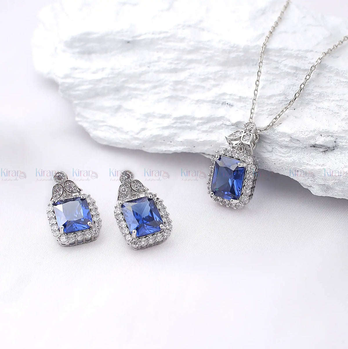 Jewelry set with blue gemstones on a white background