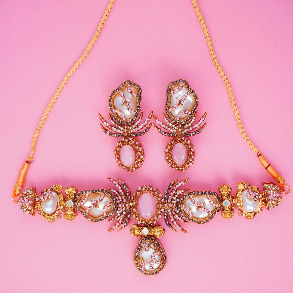 Jewelry set with necklace and earrings on a pink background