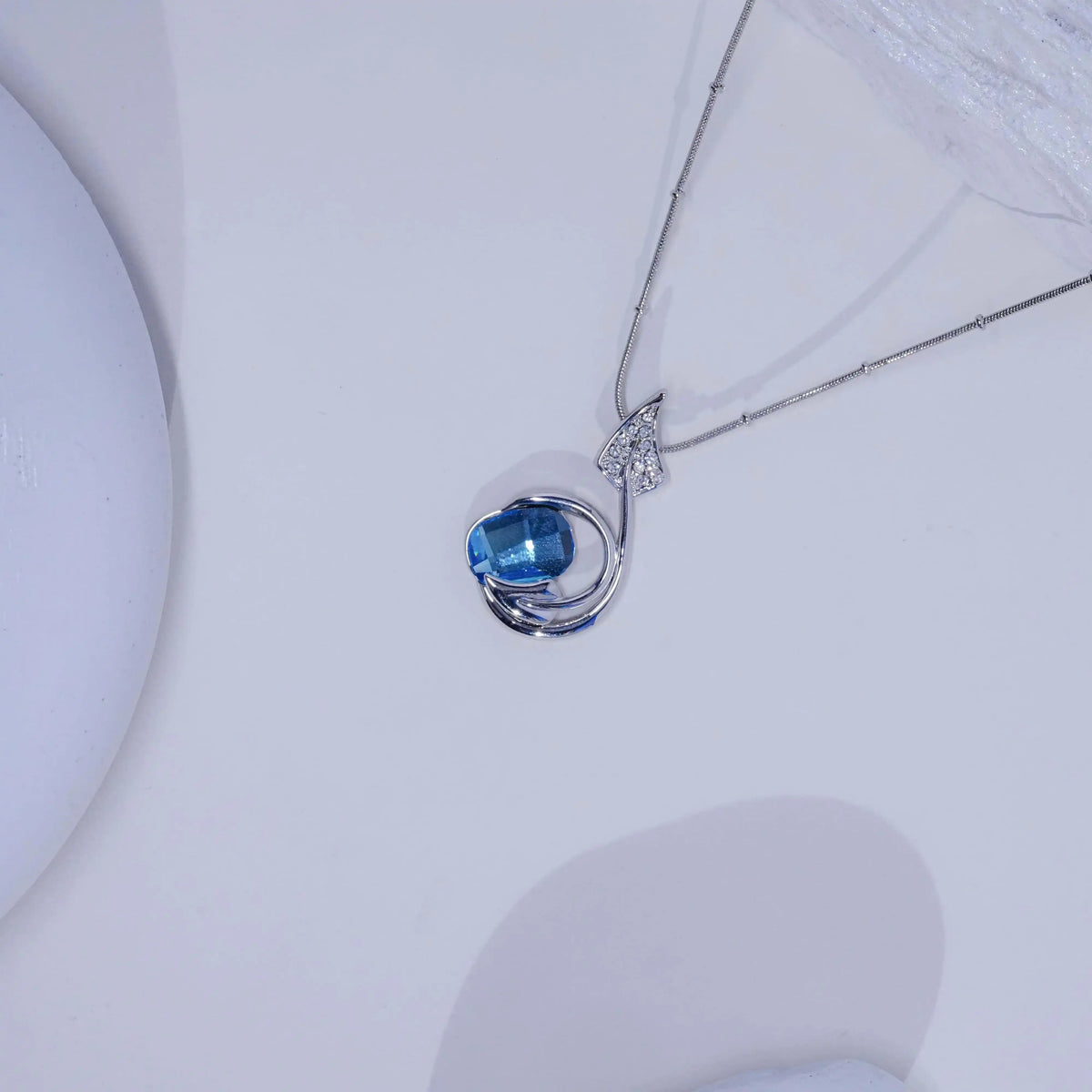 Silver necklace with a blue gemstone pendant