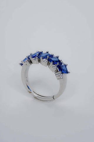 Silver ring with blue gemstones on a light gray background