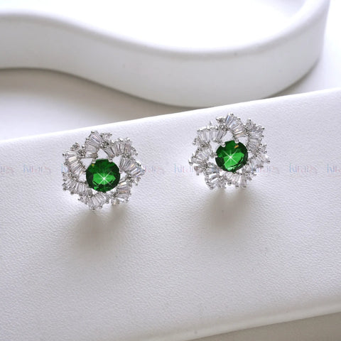 Pair of earrings with green gemstones on a white background
