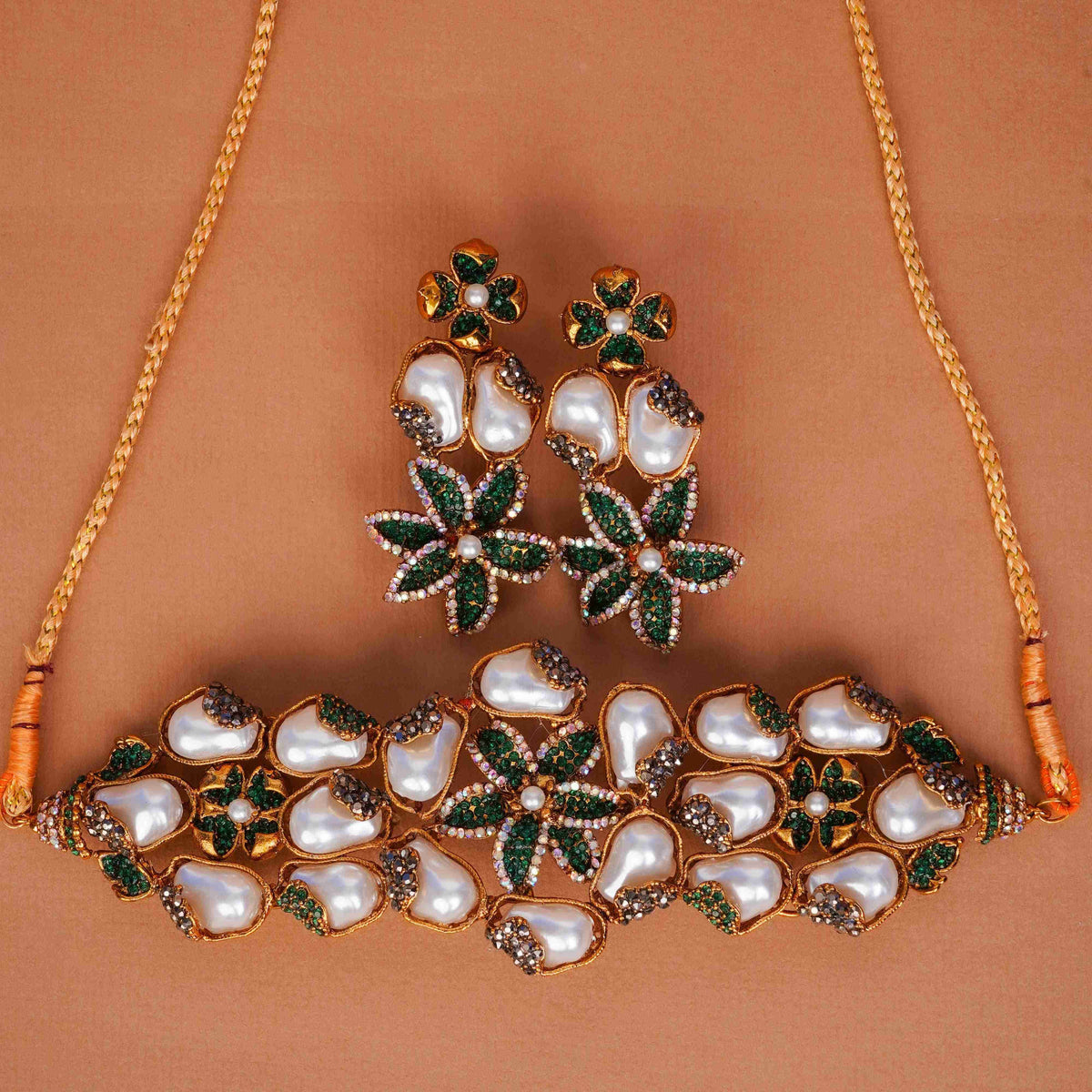 Jewelry set with necklace and earrings on a brown background