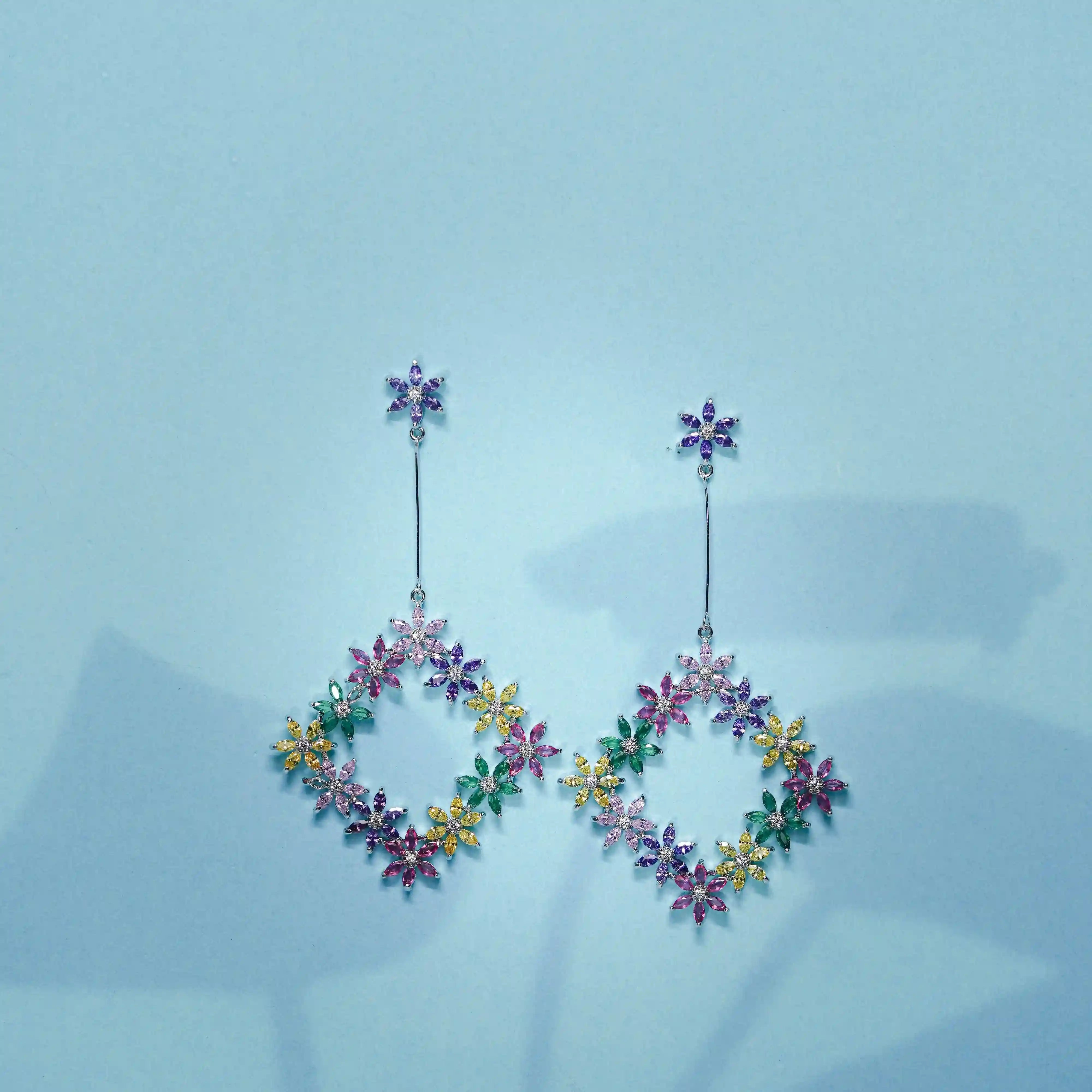Multicolored floral earrings on a light blue background