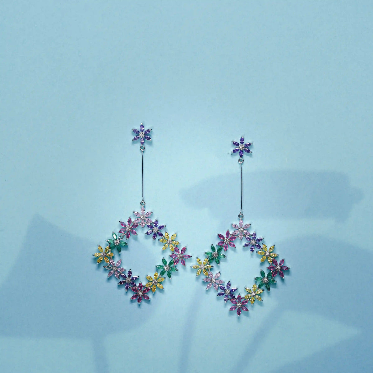 Multicolored floral earrings on a light blue background