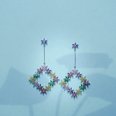 Multicolored floral earrings on a light blue background