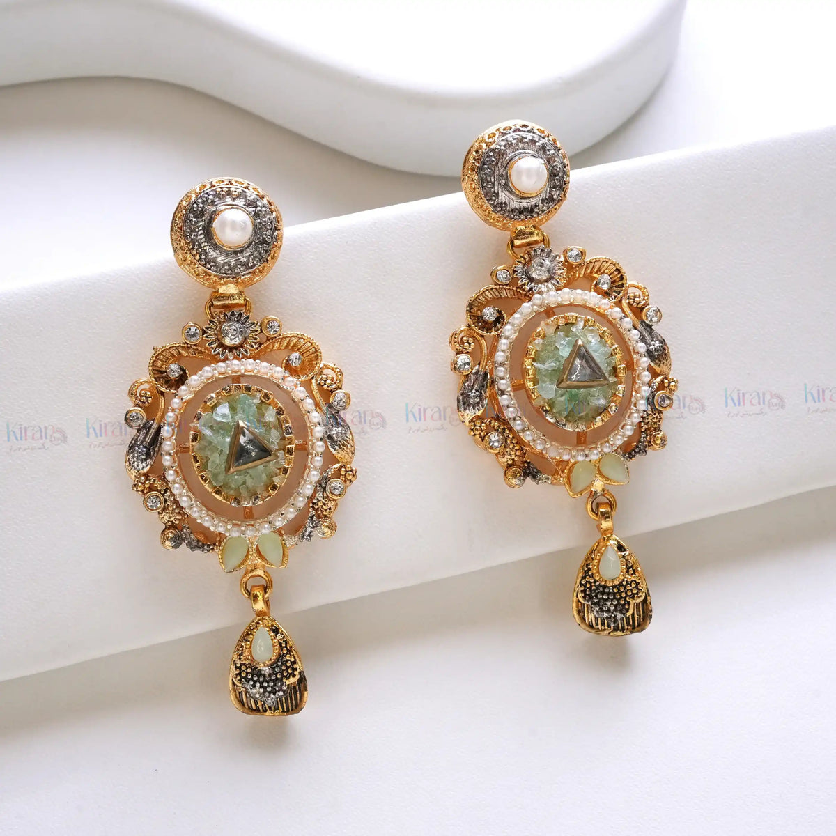 Pair of ornate gold earrings with gemstones