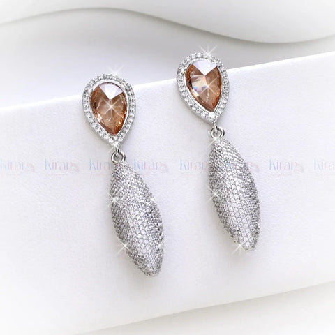 Pair of earrings with teardrop-shaped brown gemstones and silver accents on a white background.