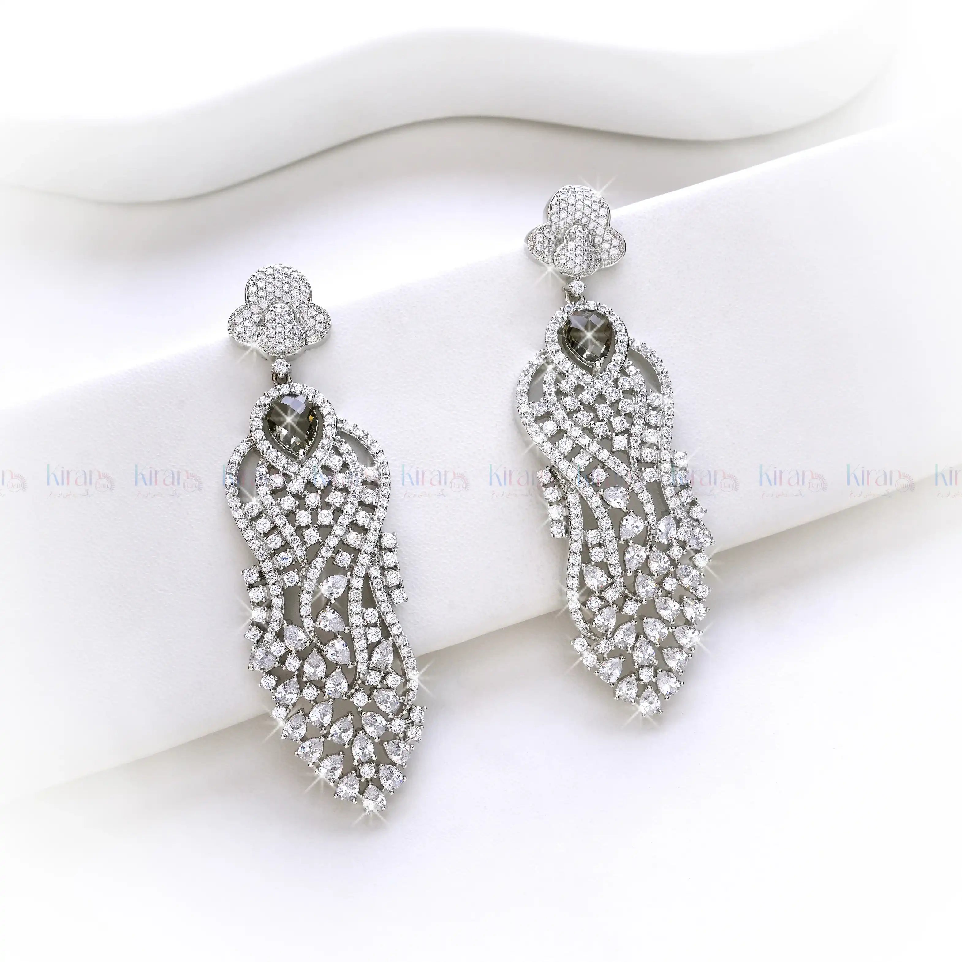 Pair of silver earrings with intricate designs on a white background