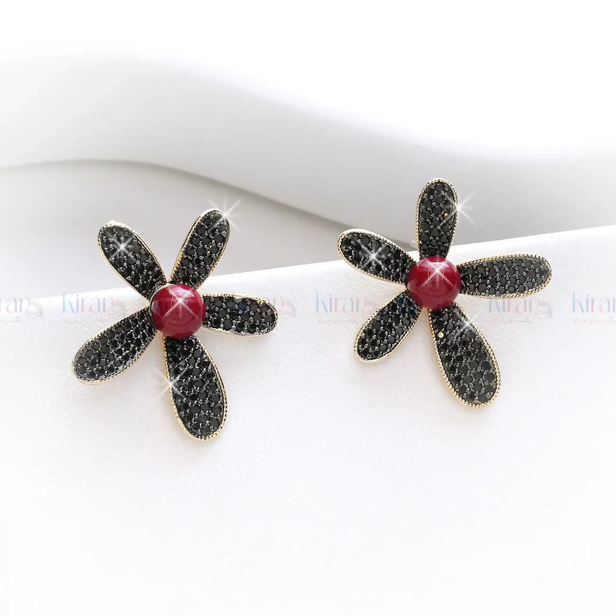 Flower-shaped earrings with black petals and a red center