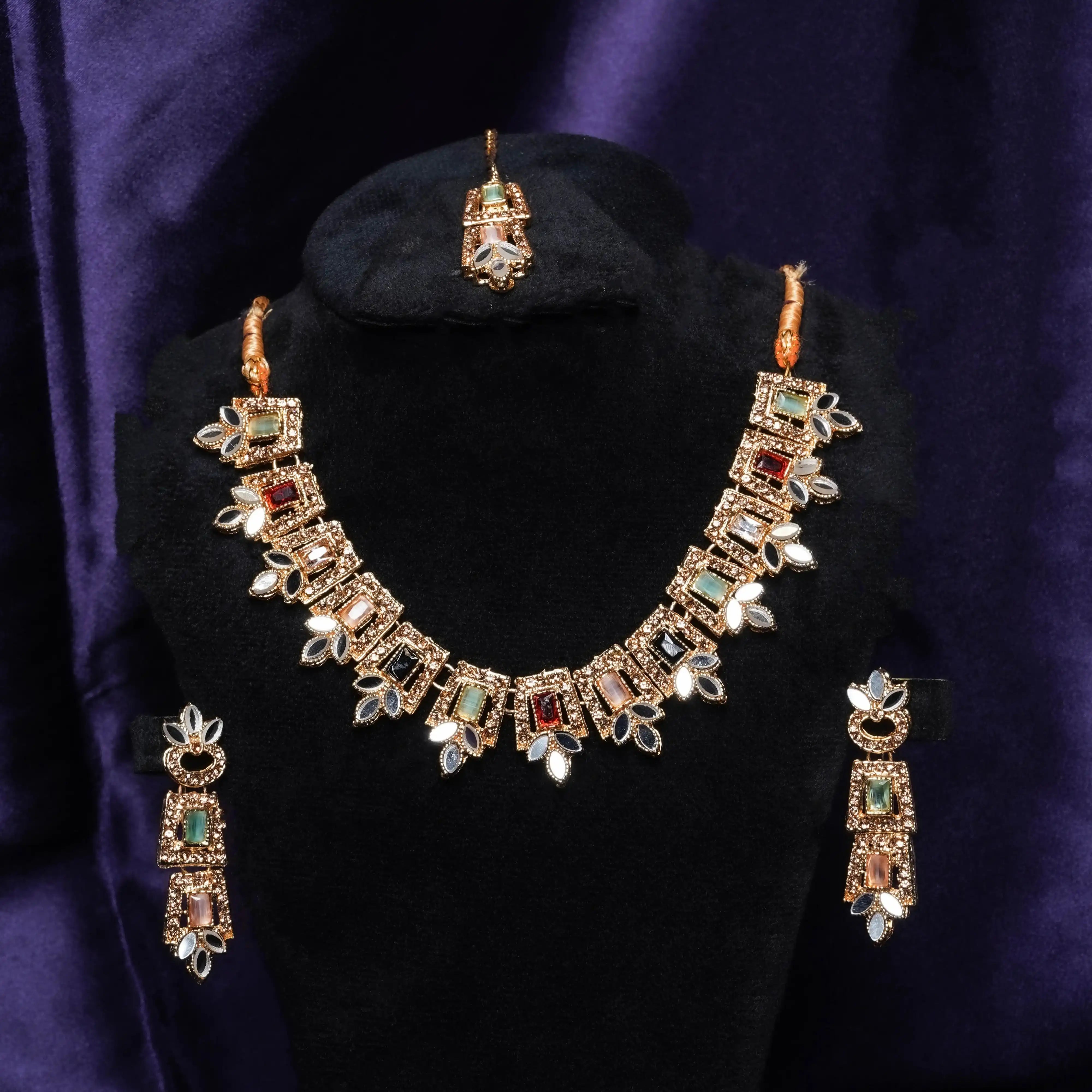 Jewelry set with necklace, earrings, and ring on a black stand against a purple fabric background