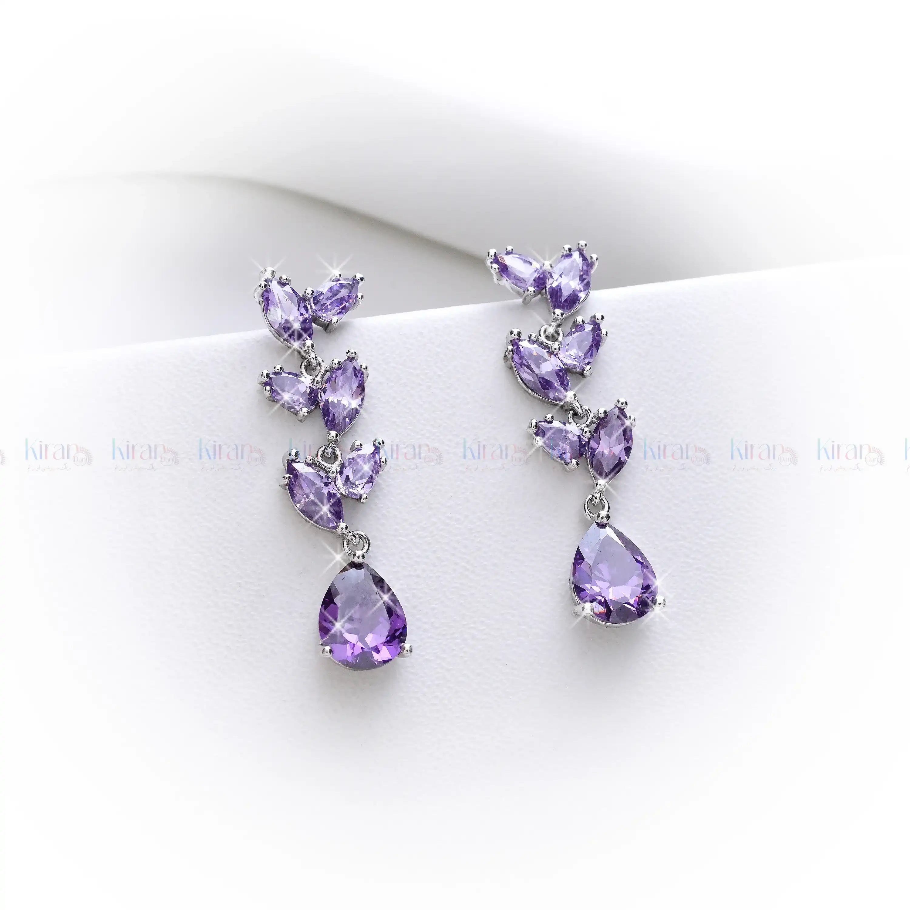 Pair of purple teardrop earrings on a white background