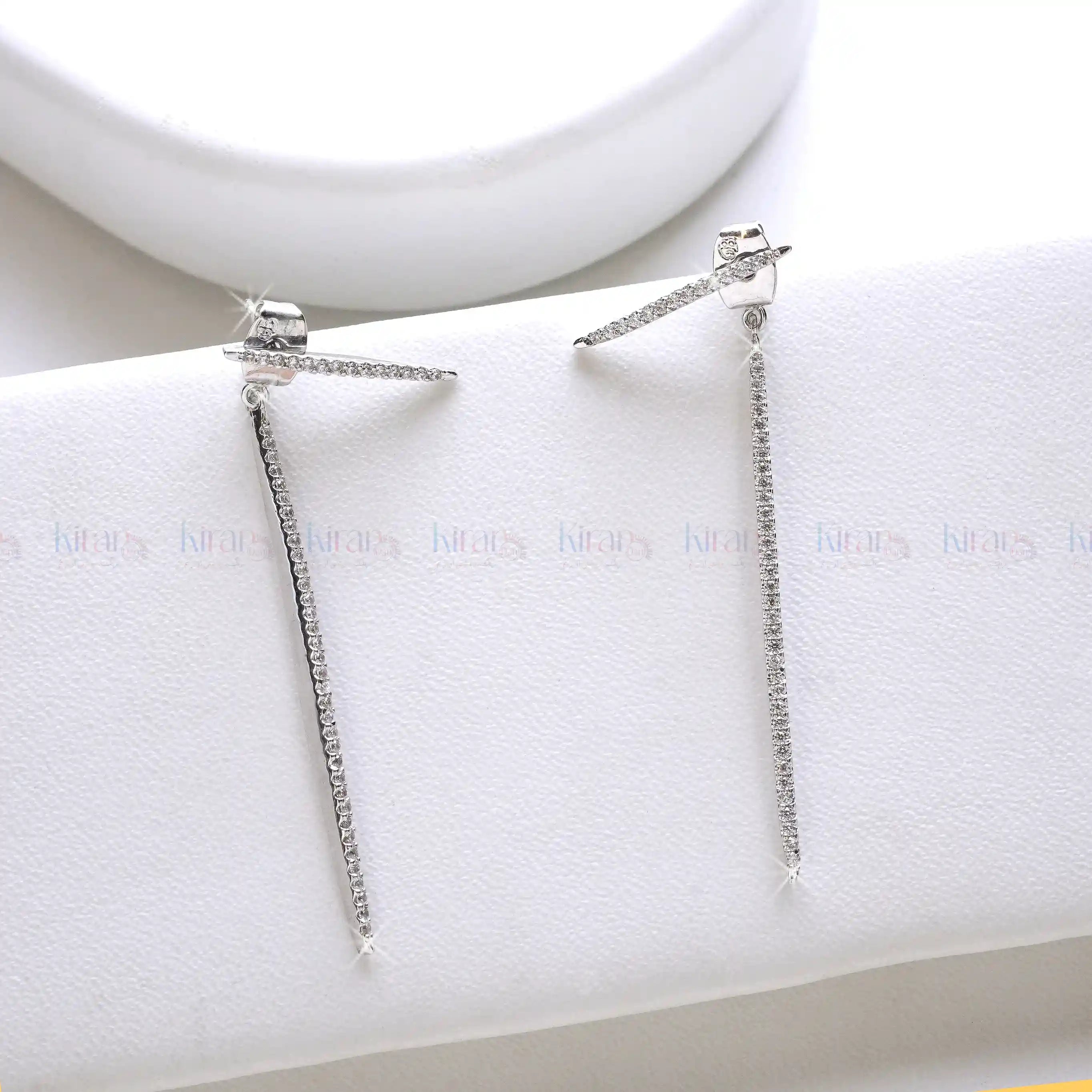 Pair of silver earrings on a white jewelry display box