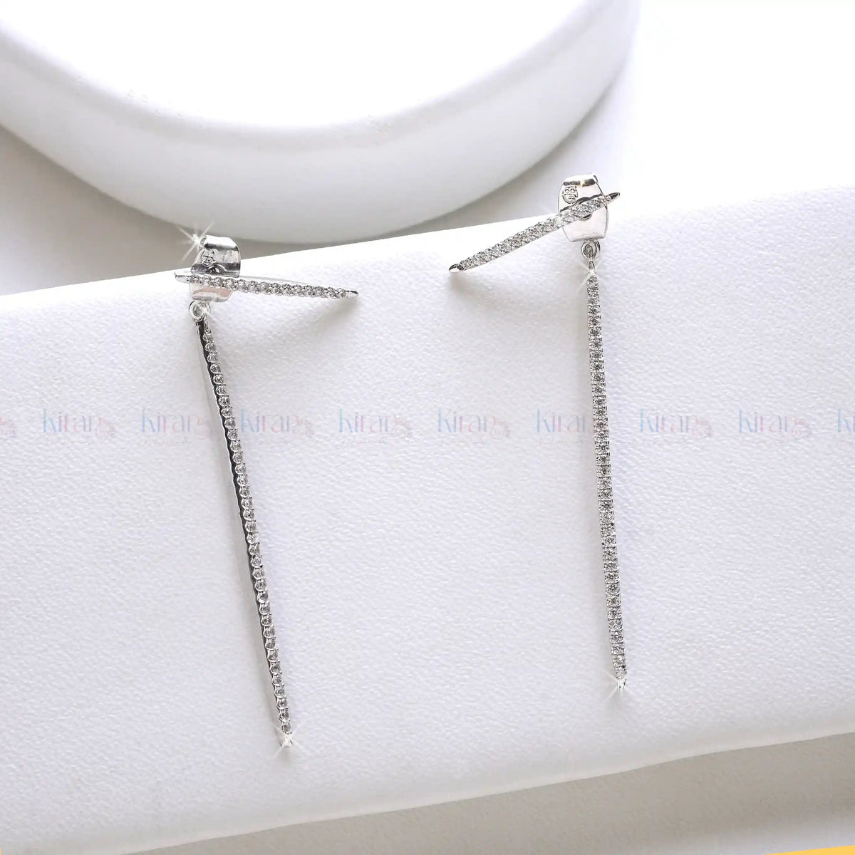 Pair of silver earrings on a white jewelry display box