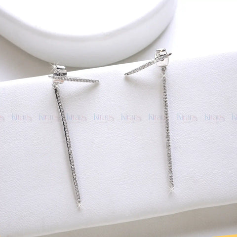 Pair of silver earrings on a white jewelry display box