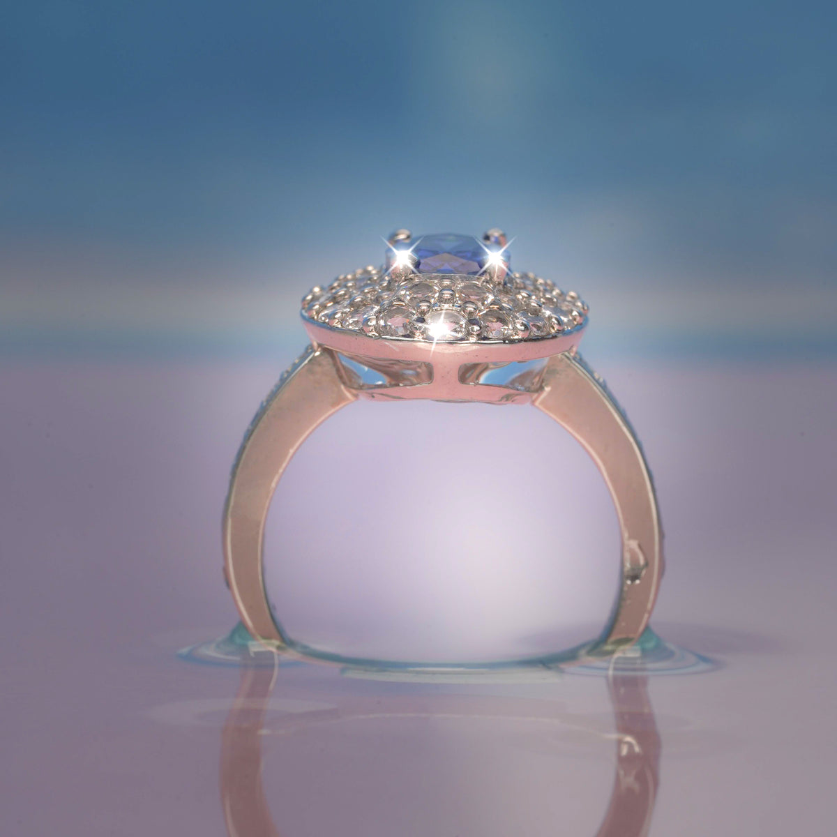 Rose gold ring with a diamond on a reflective surface