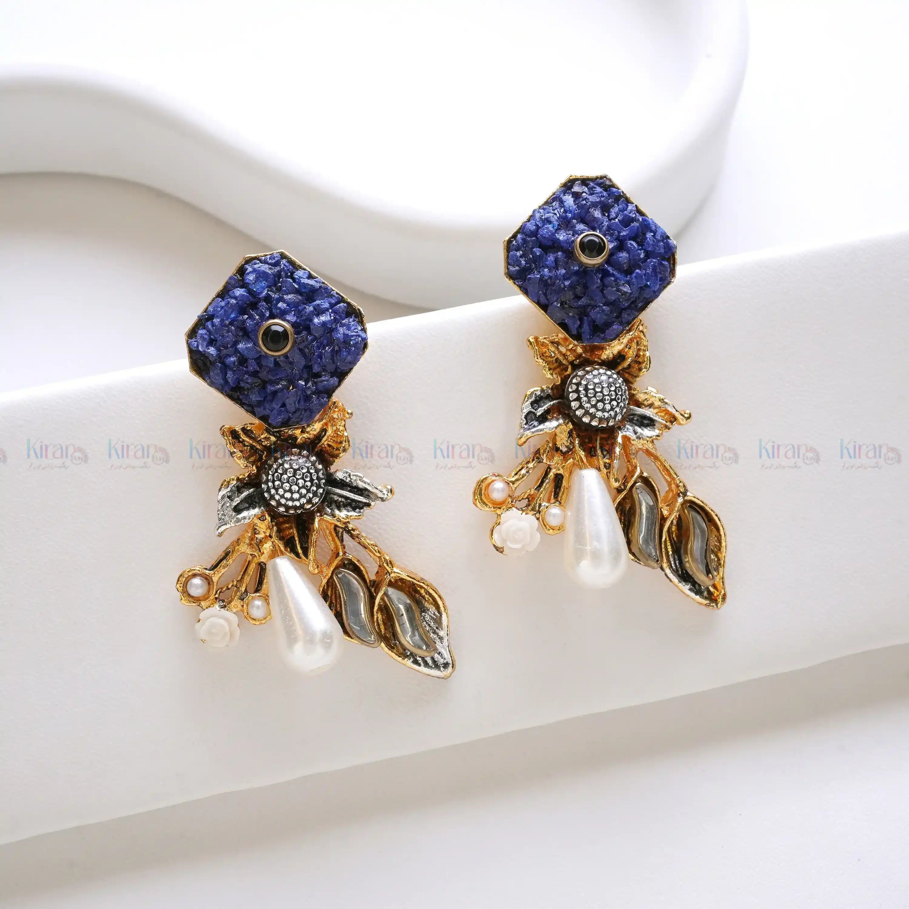Pair of ornate earrings with blue gemstones and gold accent