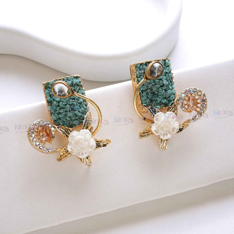 Pair of decorative earrings with green and gold design on a white surface
