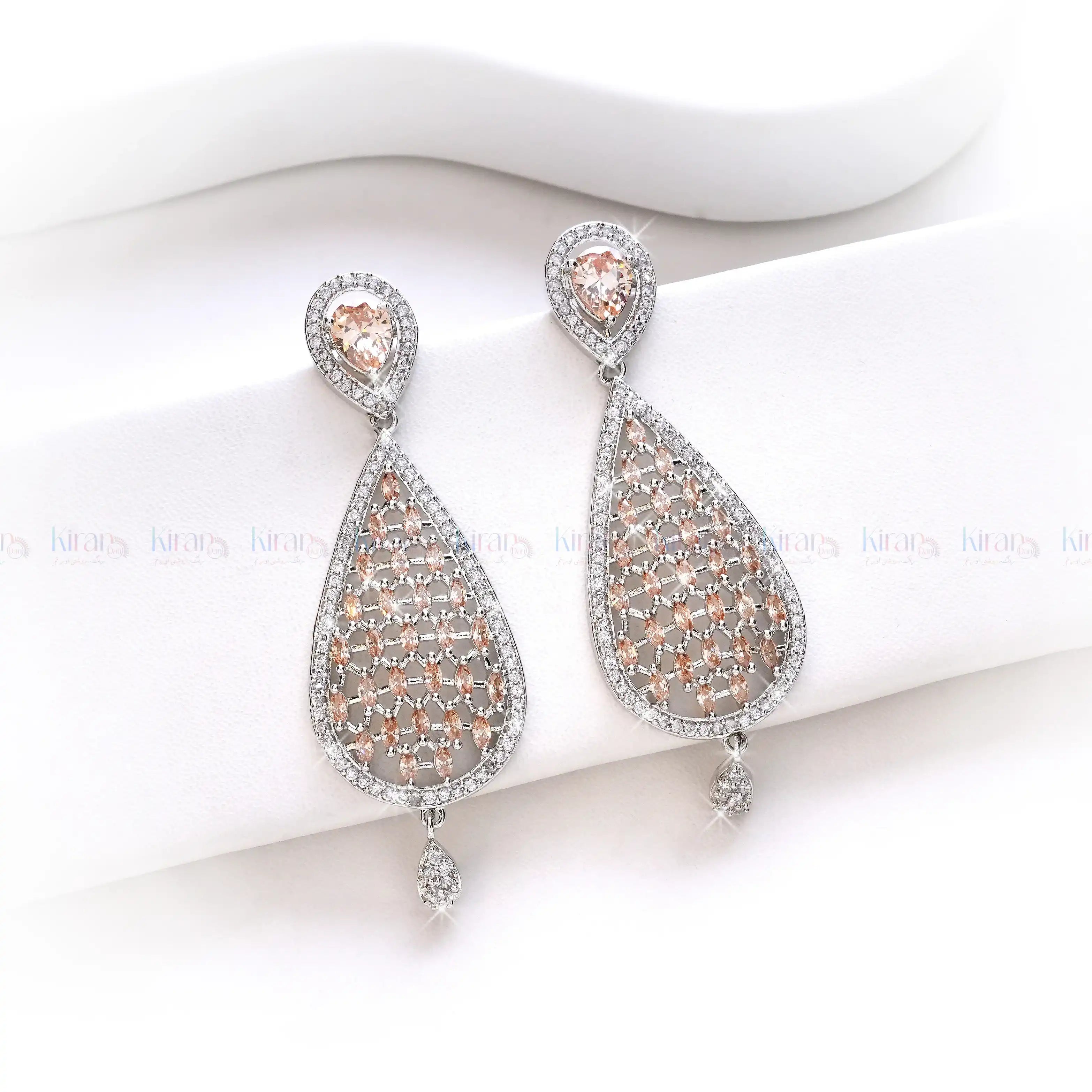 Teardrop-shaped earrings with rose gold and silver details on a white background