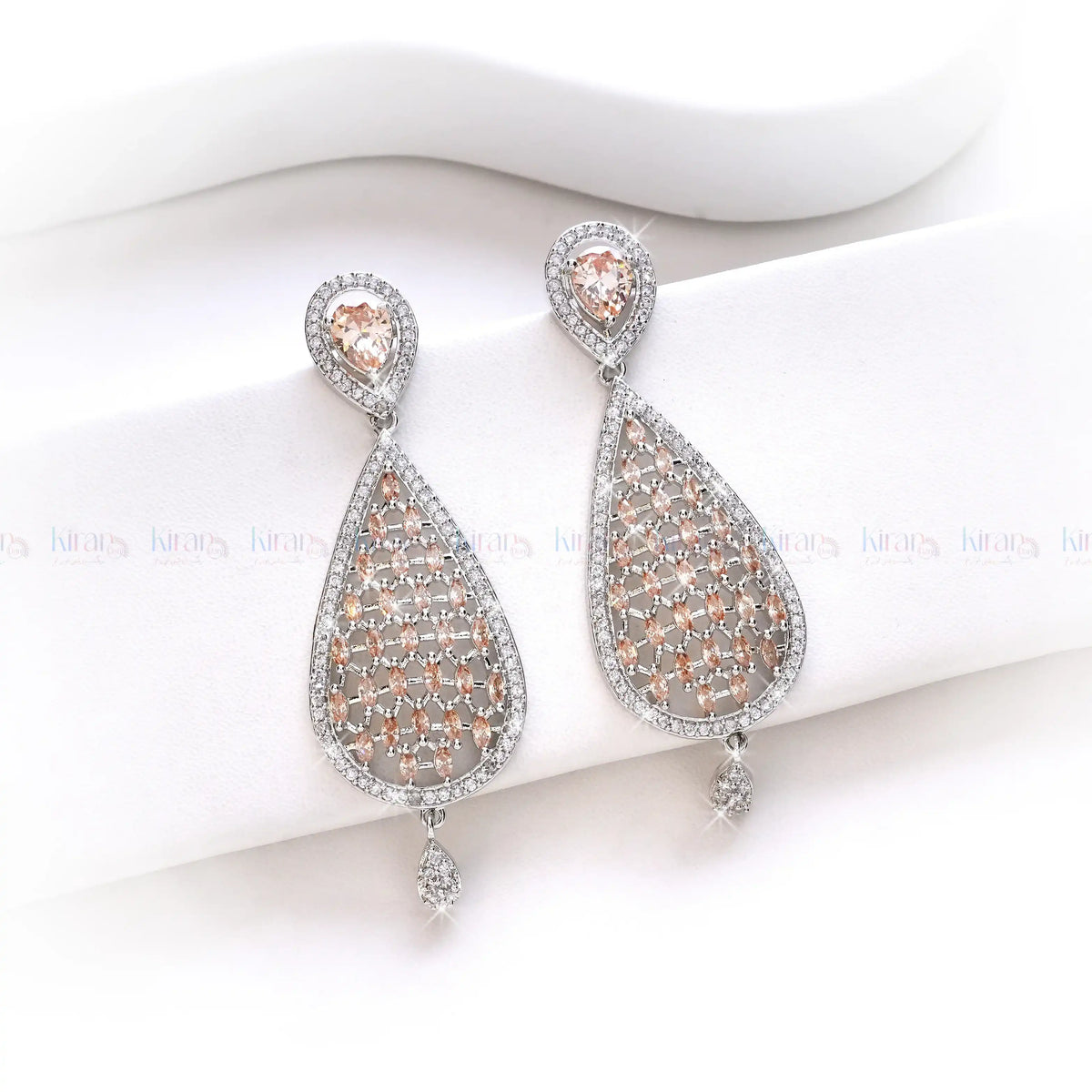 Teardrop-shaped earrings with rose gold and silver details on a white background