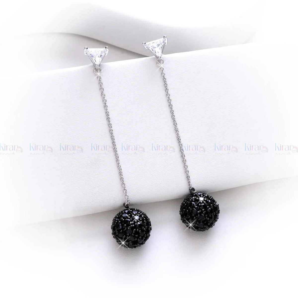 Black beaded necklace with silver chain on a white surface