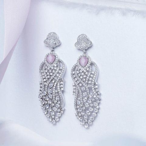 Pair of silver earrings with pink gemstones on a light background