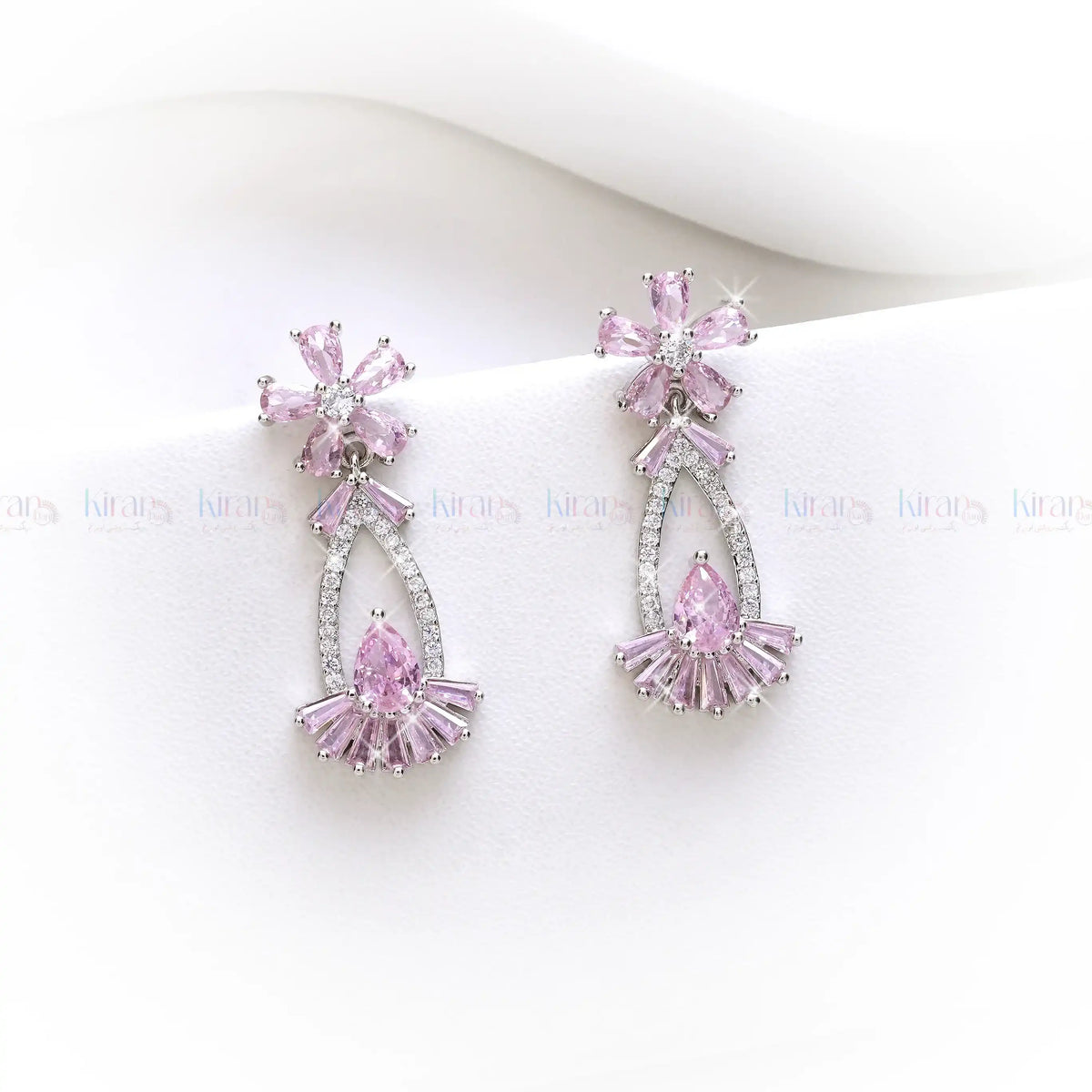 Pink and silver earrings on a white background