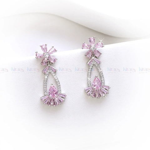 Pink and silver earrings on a white background