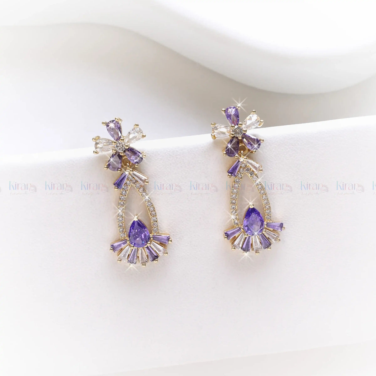 Purple earrings with gold accents on a white background