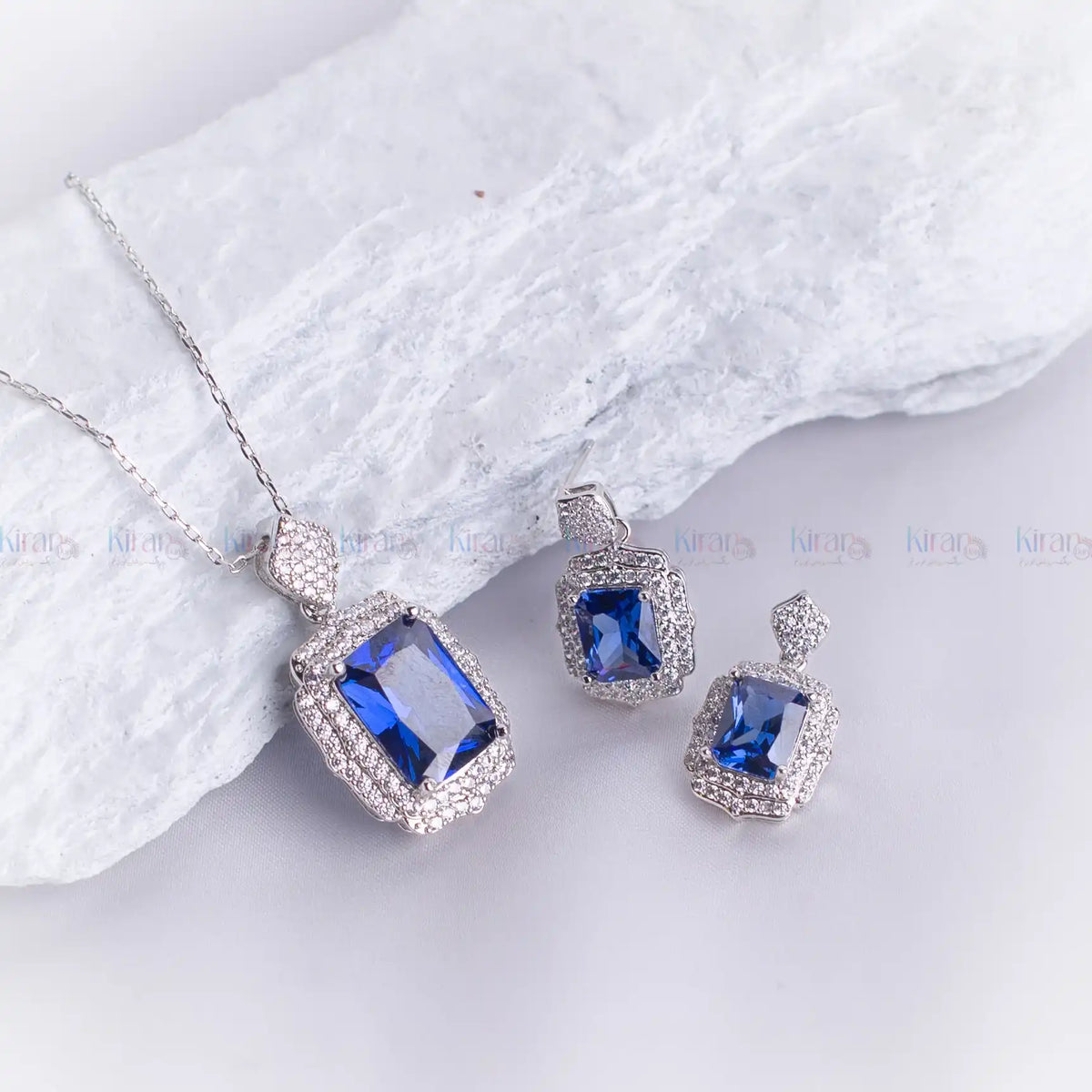 Jewelry set with blue gemstones on a white fabric background