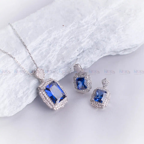 Jewelry set with blue gemstones on a white fabric background