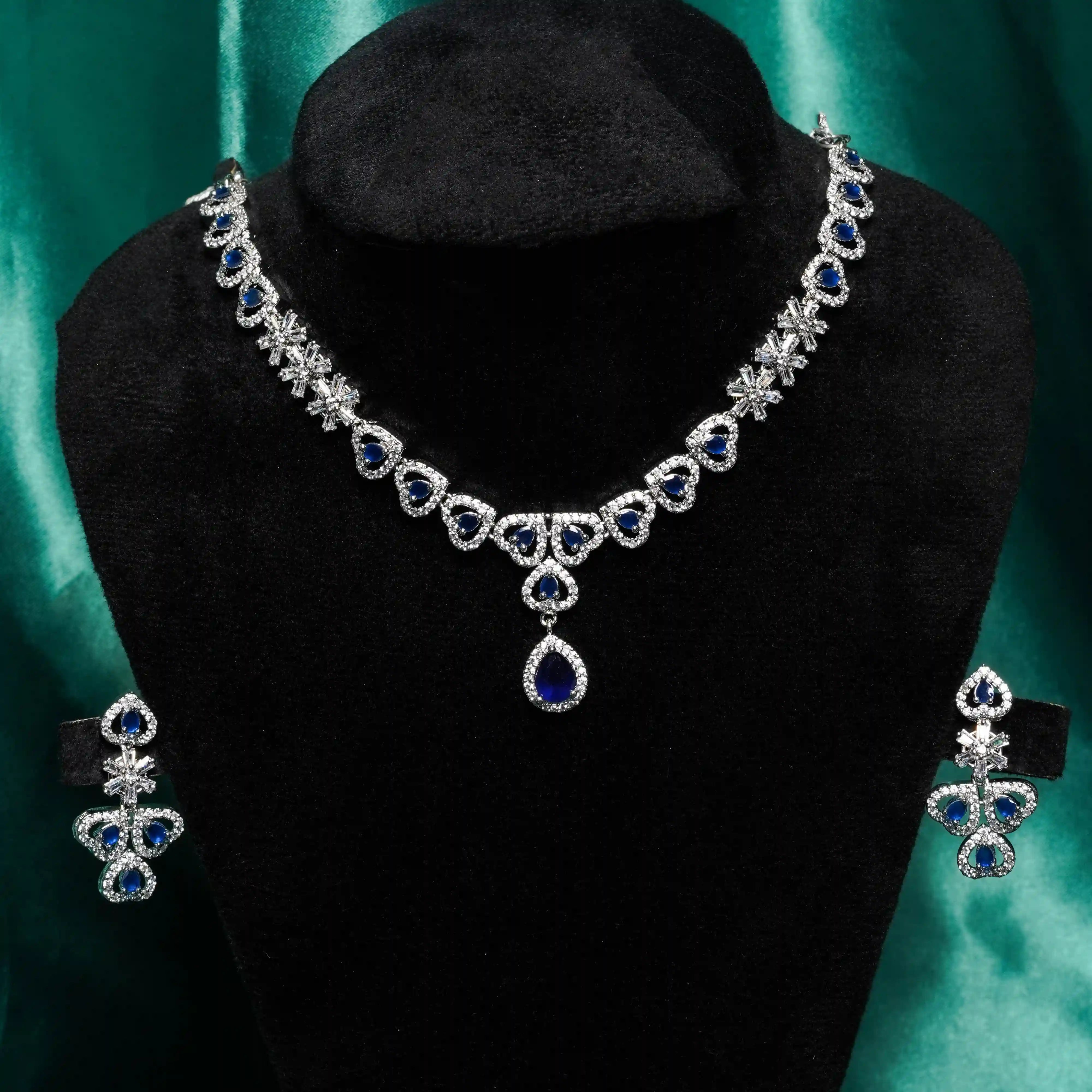 Jewelry set with necklace and earrings on a black mannequin against a green background